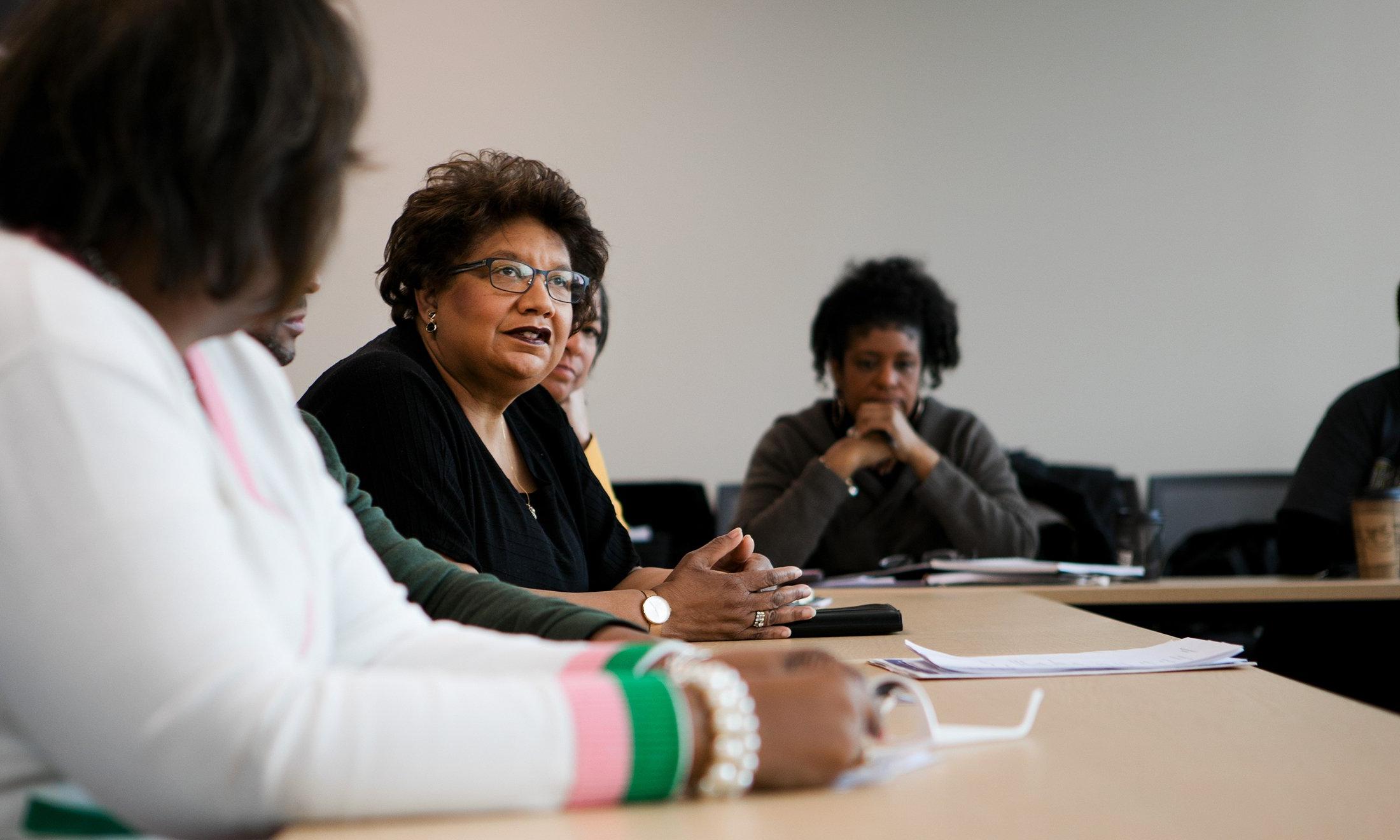 A woman at a table, talking.