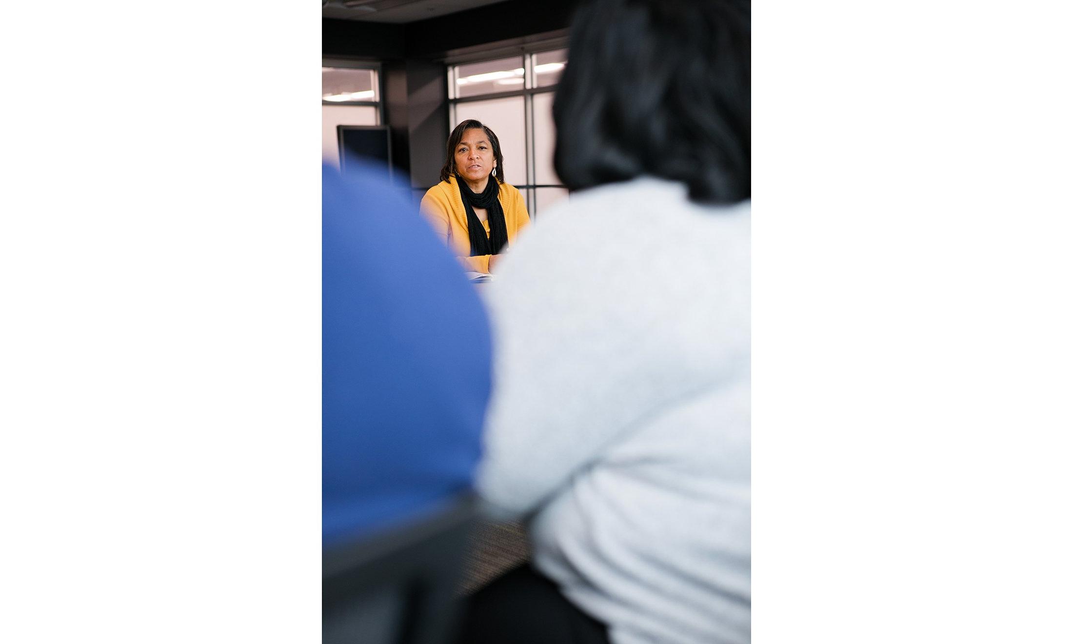 A woman at a table, talking.