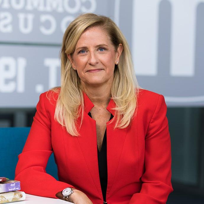 A woman smiling at a desk.