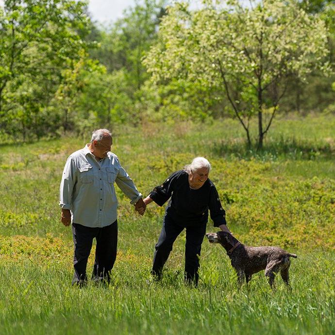 Woman, Man and dog in green field